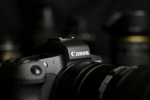 canon eos r fotokamera mit canon-objektiven auf schwarzem tisch. canon eos r ist eine spiegellose 30-MP-Vollformatkamera mit Wechselobjektiv, die 2018 von canon auf den Markt gebracht wurde foto