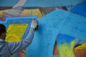 Charkow, Ukraine - 27. Mai 2017 Festival der Straßenkunst. junge kerle malen graffiti auf alte betonwände im zentrum der stadt. der Vorgang des Bemalens von Wänden mit Aerosol-Sprühdosen foto