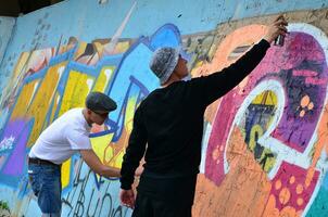 Charkow, Ukraine - 27. Mai 2017 Festival der Straßenkunst. junge kerle malen graffiti auf alte betonwände im zentrum der stadt. der Vorgang des Bemalens von Wänden mit Aerosol-Sprühdosen foto