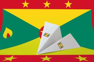 Grenada Flagge abgebildet auf Papier Origami Flugzeug. handgemacht Kunst Konzept foto