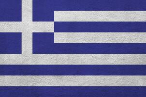 griechische flagge in hellen farben auf alter reliefputzwand dargestellt. strukturierte Fahne auf rauem Hintergrund foto