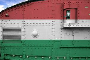 ungarn flagge auf seitenteil des militärischen gepanzerten panzers in der nähe abgebildet. konzeptioneller hintergrund der armee foto