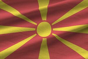 mazedonische flagge mit großen falten, die in der nähe unter dem studiolicht im innenbereich wehen. die offiziellen symbole und farben im banner foto