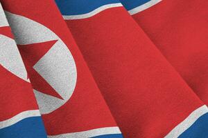 nordkorea-flagge mit großen falten, die nah oben unter dem studiolicht drinnen winken. die offiziellen symbole und farben im banner foto