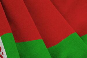 belarussische flagge mit großen falten, die im innenbereich unter dem studiolicht wehen. die offiziellen symbole und farben im banner foto