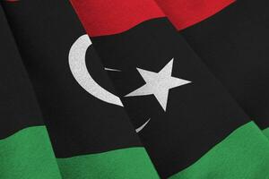 Libyen-Flagge mit großen Falten, die im Innenbereich unter dem Studiolicht wehen. die offiziellen symbole und farben im banner foto