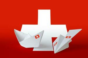 Schweiz Flagge abgebildet auf Papier Origami Flugzeug und Boot. handgemacht Kunst Konzept foto