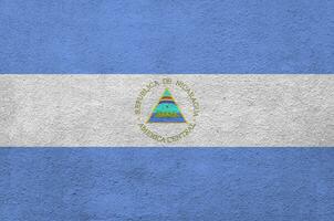 nicaragua-flagge in hellen farben auf alter reliefputzwand dargestellt. strukturierte Fahne auf rauem Hintergrund foto