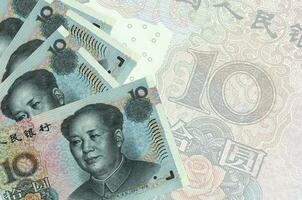 10 chinesische Yuan-Scheine liegen im Stapel auf dem Hintergrund einer großen halbtransparenten Banknote. abstrakter betriebswirtschaftlicher hintergrund foto
