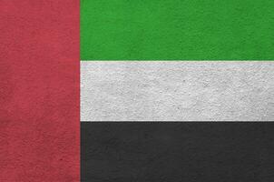 die flagge der vereinigten arabischen emirate ist in hellen farben auf der alten reliefputzwand dargestellt. strukturierte Fahne auf rauem Hintergrund foto