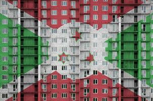 Burundi Flagge abgebildet im Farbe Farben auf mehrstöckig wohnhaft Gebäude unter Konstruktion. texturiert Banner auf Backstein Mauer Hintergrund foto