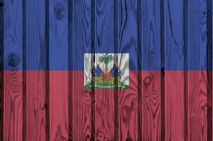 Haiti Flagge abgebildet im hell Farbe Farben auf alt hölzern Mauer. texturiert Banner auf Rau Hintergrund foto