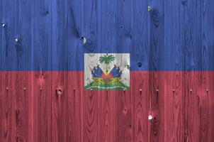 Haiti Flagge abgebildet im hell Farbe Farben auf alt hölzern Mauer. texturiert Banner auf Rau Hintergrund foto