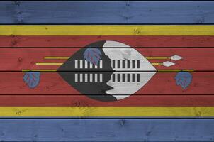 Swasiland Flagge abgebildet im hell Farbe Farben auf alt hölzern Mauer. texturiert Banner auf Rau Hintergrund foto