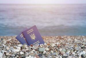 Zwei biometrische ukrainische Pässe auf Meeresküstenhintergrund foto