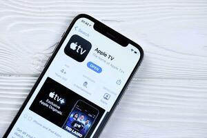 Charkow, Ukraine - - März 5, 2021 Apfel Fernseher Symbol und Anwendung von App Geschäft auf iPhone 12 Profi Anzeige Bildschirm auf Weiß Tabelle foto