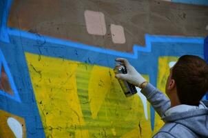 Charkow, Ukraine - 27. Mai 2017 Festival der Straßenkunst. junge kerle malen graffiti auf alte betonwände im zentrum der stadt. der Vorgang des Bemalens von Wänden mit Aerosol-Sprühdosen foto