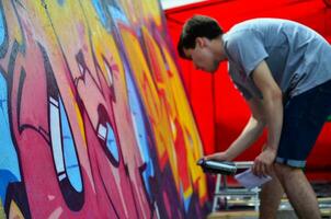 Charkow, Ukraine - 27. Mai 2017 Festival der Straßenkunst. Junge Männer malen Graffiti auf tragbare Holzwände im Zentrum der Stadt. der Vorgang des Bemalens von Wänden mit Aerosol-Sprühdosen foto