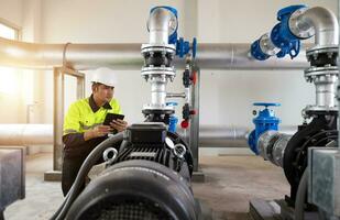 Instandhaltung Ingenieure prüfen das System von Pumpen Stationen und Rohre liefern sauber Wasser und Wasser Lager Panzer zum das Gemeinschaft. foto