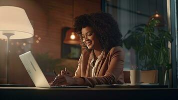 lächelnd afrikanisch amerikanisch Geschäftsfrau Sitzung beim Tabelle im ihr Zuhause Büro, lesen Unterlagen und Arbeiten mit Laptop foto