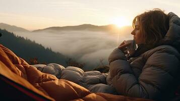 Mädchen Wanderer im ein Zelt und halten ein Tasse Berge im das Hintergrund foto