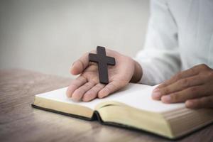 Frau mit Kreuz in den Händen, die morgens um Segen von Gott, Spiritualität und Religion betet foto