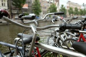 Reihe von Fahrräder im amsterdam, Niederlande, Nächster zu das Wasser foto