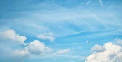 ein Weiß Flugzeug im das Himmel mit schön Weiß Wolken. reisen, Flug, Freiheit foto