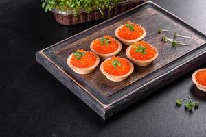 leckerer frischer roter Kaviar auf einem dunklen Betontisch