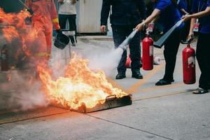 Mitarbeiter Feuerlöschtraining, Löschen eines Feuers. foto