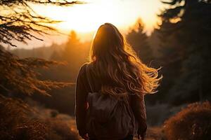 schön jung Frau mit ein Rucksack im das Strahlen von das Sonnenuntergang. Tourismus, Wandern im Natur foto