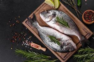 roher Dorado-Fisch mit Gewürzen, die auf Schneidebrett kochen. frischer Fisch Dorado foto