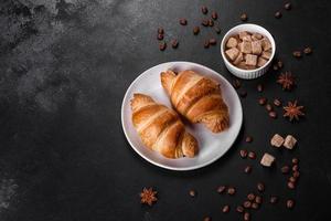 frisches knackiges leckeres französisches Croissant mit einer Tasse duftendem Kaffee foto