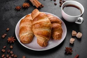 frisches knackiges leckeres französisches Croissant mit einer Tasse duftendem Kaffee foto