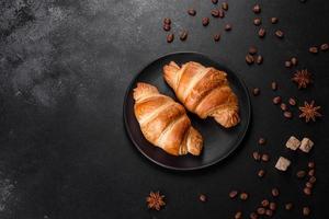 frisches knackiges leckeres französisches Croissant mit einer Tasse duftendem Kaffee foto