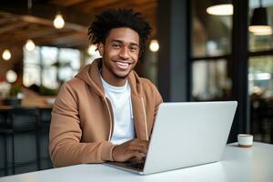 Porträt von heiter schwarz männlich Schüler Lernen online im Kaffee Geschäft, jung afrikanisch amerikanisch Mann Studien mit Laptop im Cafe, tun Hausaufgaben foto