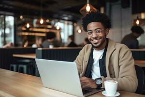 Porträt von heiter schwarz männlich Schüler Lernen online im Kaffee Geschäft, jung afrikanisch amerikanisch Mann Studien mit Laptop im Cafe, tun Hausaufgaben foto