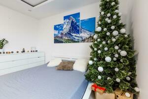 Design Zimmer mit Weihnachten Tanne und das Bett. Innere Land Stil foto