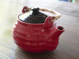 rote chinesische Teekanne auf einem Holztisch foto