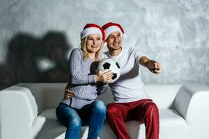 fasziniert Mann und Frau Aufpassen Fußball Spiel foto