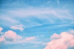 ein Weiß Flugzeug im das Himmel mit schön Rosa Wolken. reisen, Flug, Freiheit foto