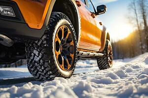 Seite Aussicht von ein Orange Auto mit ein Winter Reifen auf ein schneebedeckt Straße im sonnig Winter Tag foto