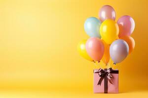 Rosa Geschenk Box mit dunkel rot Bänder und bunt Luftballons auf ein Gelb Hintergrund foto