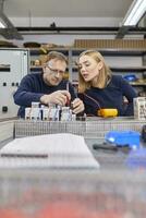 zwei Elektriker Arbeiten auf Schaltung im Werkstatt foto