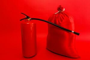 Santa Tasche und Feuer Feuerlöscher isoliert rot Hintergrund foto