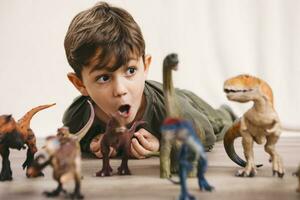 Porträt von wenig Junge spielen mit Spielzeug Dinosaurier foto