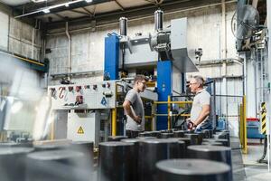 jung männlich Ingenieur Hören zu reifen Mitarbeiter während Treffen im Industrie foto