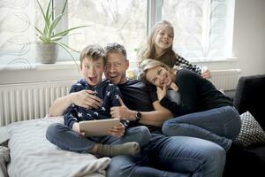 Porträt von spielerisch Familie auf Couch beim Zuhause foto