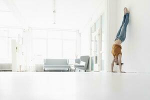 Frau tun Handstand im ein Dachgeschoss foto