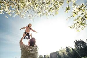 Vater werfen wenig Tochter im Luft foto